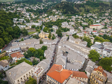 Aerial view of the historic Old Bazaar featuring traditional Ottoman stone houses with grey slate roofs and narrow streets in Gjirokaster Gjirokaster County Albania. Aerial view of the historic Old Bazaar featuring traditional Ottoman stone houses with grey slate roofs and narrow streets in Gjirokaster Gjirokaster County Albania.