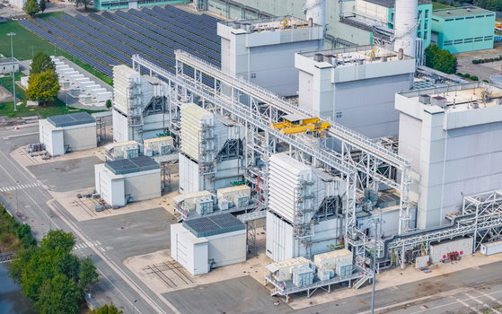 Aerial view of modern combined cycle power generation units with heat recovery equipment and solar panels at an industrial energy facility in Chivasso Piedmont Italy.