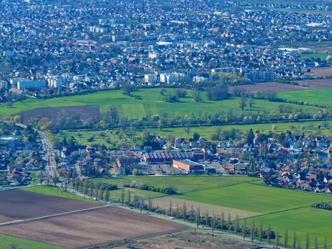 Aerial view of the city s tapestry where urban blocks meet vibrant green fields creating a peaceful contrast Sausheim Grand Est France.
