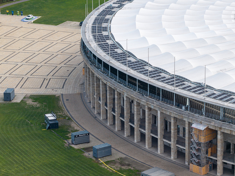 Berlin Germany 26 September 2026 Aerial view of the iconic Olympiastadion Berlin showcasing its historic stone columns modern white roof canopy and the surrounding paved plaza.
