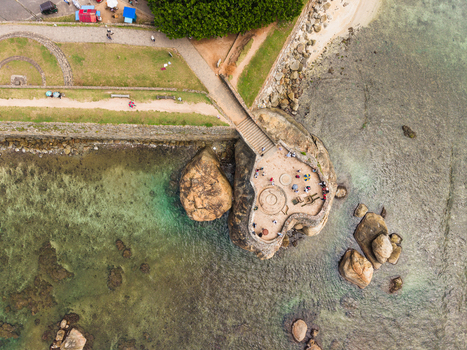Aerial view of the historic Galle Fort bastion with people on the stone platform overlooking the turquoise ocean and rocky coastline in Galle Southern Province Sri Lanka. Aerial view of the historic Galle Fort bastion with people on the stone platform overlooking the turquoise ocean and rocky coastline in Galle Southern Province Sri Lanka.