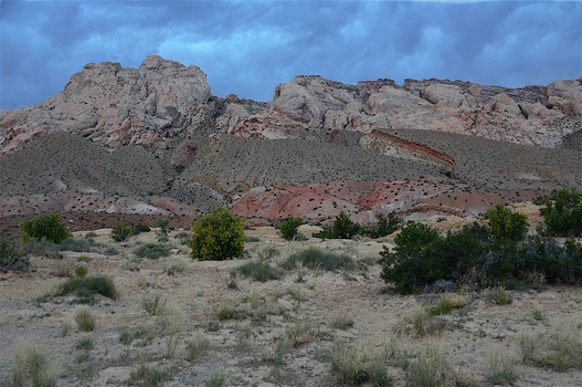View of the rugged desert landscape and rocky cliffs in the backcountry of Death Valley National Park under a dramatic cloudy sky in Death Valley California United States.