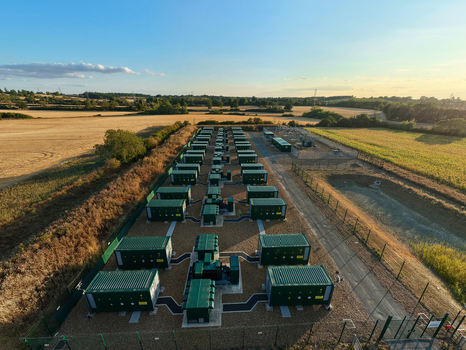 Aerial view of the Battery Energy Storage System at BESS Grendon with rows of green battery containers on a gravel site surrounded by agricultural fields in Northampton England United Kingdom. Aerial view of the Battery Energy Storage System at BESS Grendon with rows of green battery containers on a gravel site surrounded by agricultural fields in Northampton England United Kingdom.