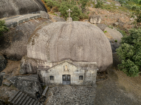 Aerial view of Santuario de Nossa Senhora da Lapa built under a massive granite boulder with a stone cross on top in Soutelo Braga Portugal. Aerial view of Santuario de Nossa Senhora da Lapa built under a massive granite boulder with a stone cross on top in Soutelo Braga Portugal.