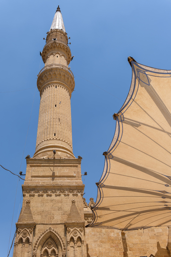 View of Imam Al Hussein Mosque with its tall stone minaret and modern sunshade under a clear blue sky Cairo Egypt. View of Imam Al Hussein Mosque with its tall stone minaret and modern sunshade under a clear blue sky Cairo Egypt.