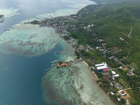 Aerial view of the Karimunjawa ferry harbour where turquoise waters meet the lush greens of the island Karimunjawa Jawa Tengah Indonesia. Aerial view of the Karimunjawa ferry harbour where turquoise waters meet the lush greens of the island Karimunjawa Jawa Tengah Indonesia.