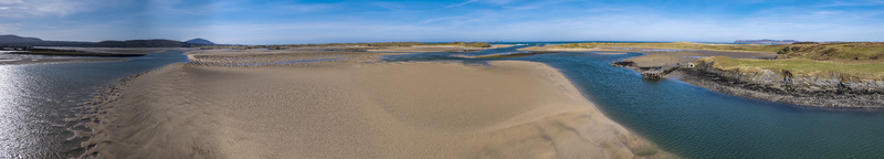 Aerial view of Ballyness Bay with expansive sandy tidal flats winding water channels and grassy dunes under a clear blue sky in Ballyness County Donegal Ireland. Aerial view of Ballyness Bay with expansive sandy tidal flats winding water channels and grassy dunes under a clear blue sky in Ballyness County Donegal Ireland.