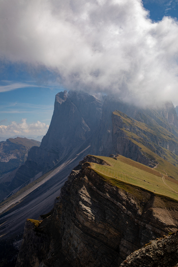 View of the jagged peaks of the Dolomites with clouds rolling over the summits and green alpine meadows Rocca Pietore Veneto Italy. View of the jagged peaks of the Dolomites with clouds rolling over the summits and green alpine meadows Rocca Pietore Veneto Italy.