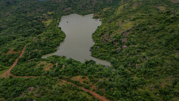 Aerial view of Lamingo Dam surrounded by lush green hills rocky terrain and dirt paths in Jos Jarawa Plateau Nigeria. Aerial view of Lamingo Dam surrounded by lush green hills rocky terrain and dirt paths in Jos Jarawa Plateau Nigeria.