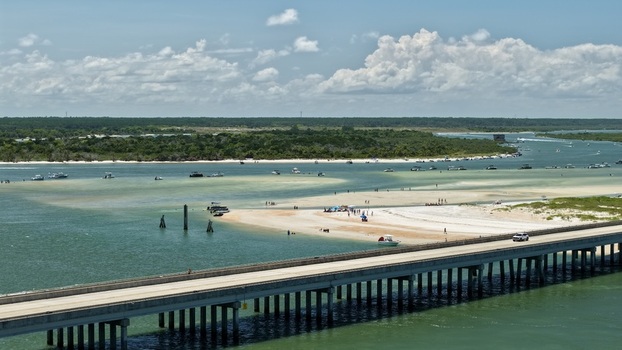 Aerial view of Matanzas Inlet featuring a bridge crossing the water sandy shoals boats and coastal vegetation in St. Johns County Florida United States. Aerial view of Matanzas Inlet featuring a bridge crossing the water sandy shoals boats and coastal vegetation in St. Johns County Florida United States.