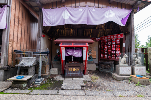 View of an ornate weathered shrine with stone fox statues and vibrant red accents nestled in a tranquil corner of Narita Chiba Japan. View of an ornate weathered shrine with stone fox statues and vibrant red accents nestled in a tranquil corner of Narita Chiba Japan.