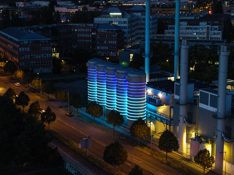 Aerial view of the BTB Heat and Power Plant Adlershof with glowing blue and purple light installations on the storage tanks at night in Berlin Berlin Germany. Aerial view of the BTB Heat and Power Plant Adlershof with glowing blue and purple light installations on the storage tanks at night in Berlin Berlin Germany.