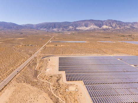 Aerial view of a large solar farm with rows of photovoltaic panels next to a long desert road and rugged mountains Lucerne Valley California United States. Aerial view of a large solar farm with rows of photovoltaic panels next to a long desert road and rugged mountains Lucerne Valley California United States.