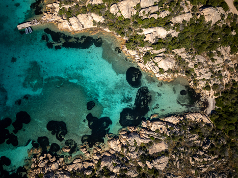 Aerial view of the rocky coastline and turquoise waters of Carlotto with granite rocks and green scrub in La Maddalena Sardinia Italy. Aerial view of the rocky coastline and turquoise waters of Carlotto with granite rocks and green scrub in La Maddalena Sardinia Italy.