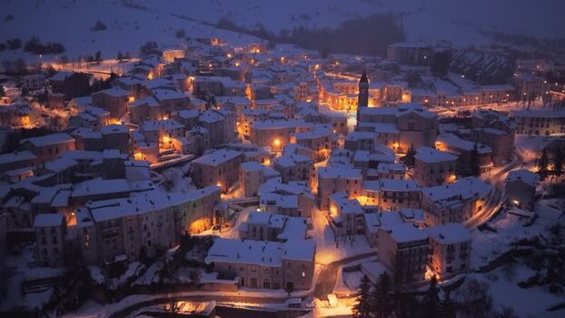 Aerial view of snowy Rivisondoli at night Italy.
