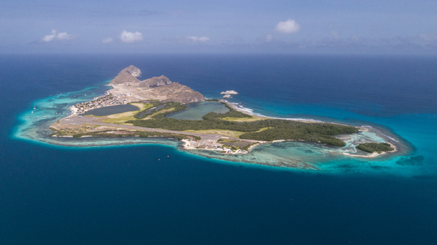 Aerial view of the Los Roques archipelago featuring turquoise waters coral reefs and an island airstrip surrounded by lush vegetation in Los Roques Dependencias Federale Venezuela. Aerial view of the Los Roques archipelago featuring turquoise waters coral reefs and an island airstrip surrounded by lush vegetation in Los Roques Dependencias Federale Venezuela.