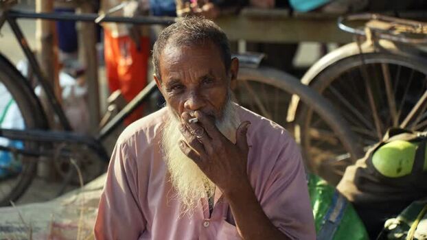 View of an elderly man smoking a cigarette in Bogura Bangladesh. View of an elderly man smoking a cigarette in Bogura Bangladesh.