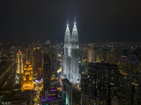 Kuala Lumpur Malaysia 11 March 2026 Aerial view of the illuminated Petronas Twin Towers rising above the city skyline at night.