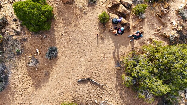 Aerial view of hikers resting in the arid landscape the ochre earth contrasting with the deep green shrubbery Palisade Colorado USA. Aerial view of hikers resting in the arid landscape the ochre earth contrasting with the deep green shrubbery Palisade Colorado USA.