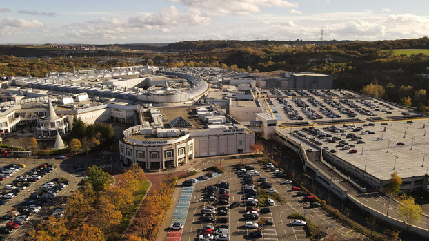 Aerial view of the Bluewater Shopping Centre with its extensive parking lots and modern architecture surrounded by autumn trees in Dartford England United Kingdom. Aerial view of the Bluewater Shopping Centre with its extensive parking lots and modern architecture surrounded by autumn trees in Dartford England United Kingdom.