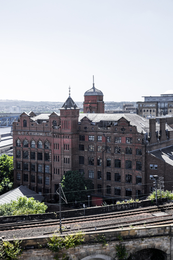 Aerial view of the historic red brick Turnbull Building with its prominent tower and ornate facade situated near railway tracks in Newcastle upon Tyne England United Kingdom. Aerial view of the historic red brick Turnbull Building with its prominent tower and ornate facade situated near railway tracks in Newcastle upon Tyne England United Kingdom.