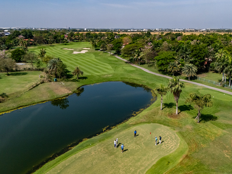 Ahmedabad Gujarat India 21 March 2026 Aerial view of Kalhaar Blues and Greens Golf Club featuring a lush green golf course a water hazard and golfers on the putting green.