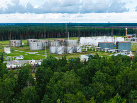 Olaine parish Latvia 04 July 2026 Aerial view of an industrial storage facility with large metal tanks and pipelines situated amidst a dense forest under a cloudy sky. Olaine parish Latvia 04 July 2026 Aerial view of an industrial storage facility with large metal tanks and pipelines situated amidst a dense forest under a cloudy sky.