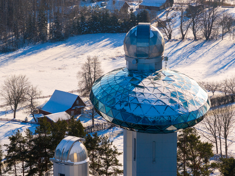 Aerial view of the Lithuanian Museum of Ethnocosmology with its futuristic glass dome overlooking a snowy winter landscape in Kulionys Utenos apskritis Lithuania.