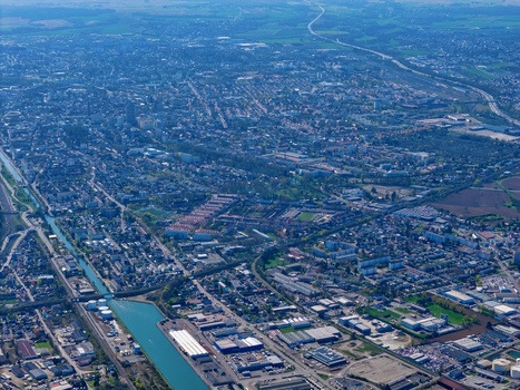 Aerial view of an intricate network of canals cutting through the urban landscape with bridges arching over the waterways and dense vegetation lining the banks Sausheim Grand Est France.