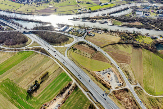 Aerial view of a highway interchange and the Main Danube Canal winding through rural fields and industrial areas in Buttenheim Bavaria Germany. Aerial view of a highway interchange and the Main Danube Canal winding through rural fields and industrial areas in Buttenheim Bavaria Germany.