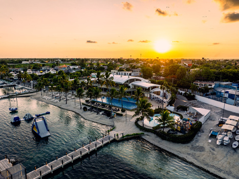 Aerial view of Club Nautico de Santo Domingo Inc. featuring a marina with boats a swimming pool palm trees and a wooden pier at sunset in Andres Santo Domingo Dominican Republic. Aerial view of Club Nautico de Santo Domingo Inc. featuring a marina with boats a swimming pool palm trees and a wooden pier at sunset in Andres Santo Domingo Dominican Republic.