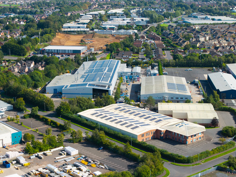 Aerial view of an industrial park featuring large warehouses with solar panels on their roofs parking areas and surrounding greenery in Lisburn Northern Ireland United Kingdom. Aerial view of an industrial park featuring large warehouses with solar panels on their roofs parking areas and surrounding greenery in Lisburn Northern Ireland United Kingdom.