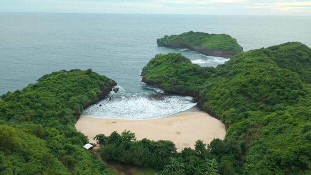 Aerial view of Sedahan Beach and lush green cliffs Indonesia.