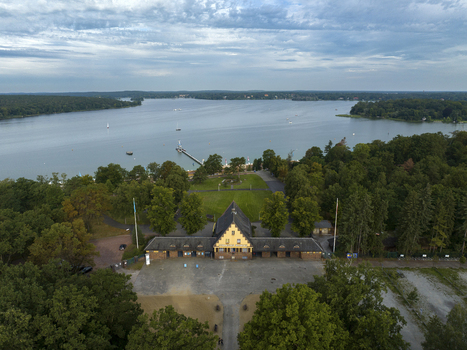Aerial view of strandbad wannsee public beach surrounded by tranquil trees and serene lake Nikolassee Germany.