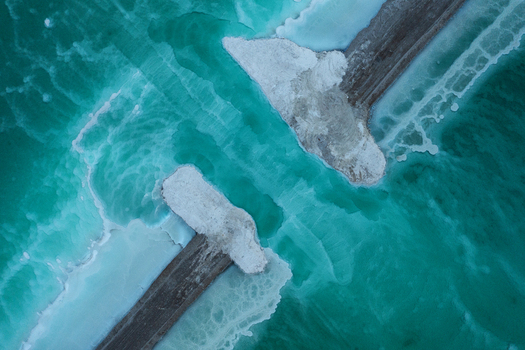 Aerial view of emerald green waters contrast sharply with the stark white salt formations along the wooden structures Dead Sea Israel. Aerial view of emerald green waters contrast sharply with the stark white salt formations along the wooden structures Dead Sea Israel.