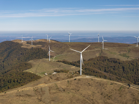 Aerial view of wind turbines on a hilly landscape with autumn forests under a clear blue sky in Bulgaria. Aerial view of wind turbines on a hilly landscape with autumn forests under a clear blue sky in Bulgaria.