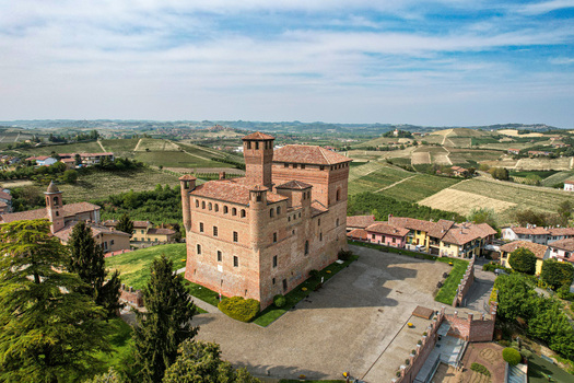 Aerial view of the historic Castle of Grinzane Cavour surrounded by rolling vineyards and the village rooftops in Grinzane Cavour Piedmont Italy. Aerial view of the historic Castle of Grinzane Cavour surrounded by rolling vineyards and the village rooftops in Grinzane Cavour Piedmont Italy.