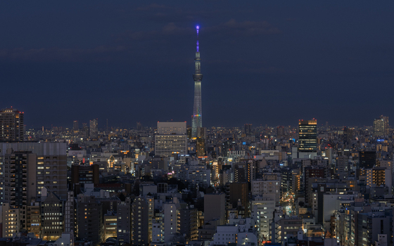 Aerial view of Tokyo Skytree illuminated at night above the dense urban skyline of Tokyo Tokyo Japan. Aerial view of Tokyo Skytree illuminated at night above the dense urban skyline of Tokyo Tokyo Japan.
