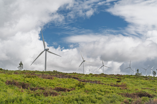 View of Parque Eolico da Serra dos Candeeiros with wind turbines on a green hillside under a cloudy sky in Rio Maior Santarem Portugal. View of Parque Eolico da Serra dos Candeeiros with wind turbines on a green hillside under a cloudy sky in Rio Maior Santarem Portugal.