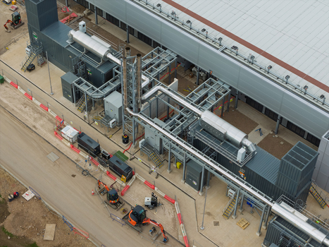 Aerial view of a data center facility featuring industrial cooling systems complex piping and construction equipment on site in the United Kingdom.