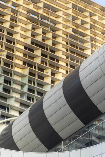 View of modern architectural details featuring a geometric grid facade and a curved striped structure in Taipei City Taiwan. View of modern architectural details featuring a geometric grid facade and a curved striped structure in Taipei City Taiwan.