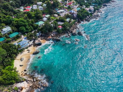 Aerial view of where turquoise waters meet the rugged coastline and lush green vegetation Vista do Mar Mahe Island Seychelles. Aerial view of where turquoise waters meet the rugged coastline and lush green vegetation Vista do Mar Mahe Island Seychelles.