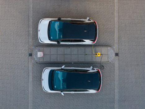 Aerial view of two electric cars charging at an ENTEGA Charging Station on a paved parking lot in Darmstadt Hessen Germany. Aerial view of two electric cars charging at an ENTEGA Charging Station on a paved parking lot in Darmstadt Hessen Germany.