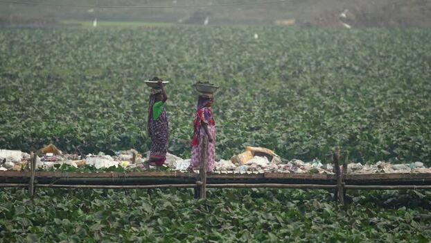 View of women carrying baskets on a bridge in Bogura Bangladesh.