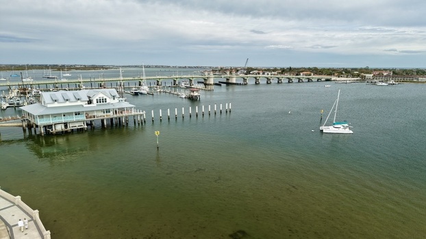 Aerial view of the Bridge of Lions and a marina with sailboats and a waterfront building on stilts in St. Augustine Florida United States.