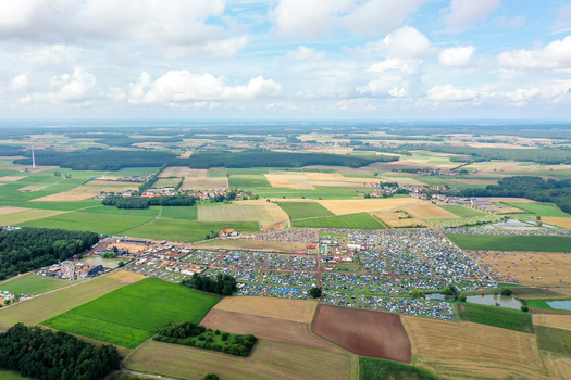 Herzogenaurach Germany 27 July 2025 Aerial view of the Open Beatz Festival site with numerous tents and stages set amidst agricultural fields and forests under a cloudy sky. Herzogenaurach Germany 27 July 2025 Aerial view of the Open Beatz Festival site with numerous tents and stages set amidst agricultural fields and forests under a cloudy sky.