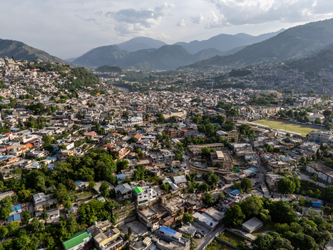 Aerial view of Muzaffarabad city nestled in a valley with dense buildings lush trees and a river flowing through the landscape in Muzaffarabad Azad Kashmir Pakistan. Aerial view of Muzaffarabad city nestled in a valley with dense buildings lush trees and a river flowing through the landscape in Muzaffarabad Azad Kashmir Pakistan.