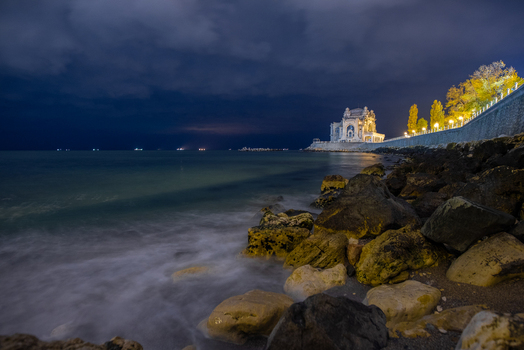 View of the historic Constanta Casino illuminated on the rocky Black Sea coastline in Constanta Judetul Constanta Romania. View of the historic Constanta Casino illuminated on the rocky Black Sea coastline in Constanta Judetul Constanta Romania.