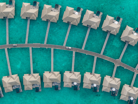 Aerial view of light roofed overwater bungalows and winding paths amidst turquoise waters Hoarafushi Thiladhunmathee Uthuruburi Maldives. Aerial view of light roofed overwater bungalows and winding paths amidst turquoise waters Hoarafushi Thiladhunmathee Uthuruburi Maldives.