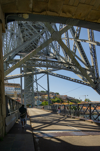 Porto Portugal 13 July 2021 View of the Dom Luís I Bridge s intricate metal latticework against the clear sky as pedestrians stroll along the sunlit upper deck.. Porto Portugal 13 July 2021 View of the Dom Luís I Bridge s intricate metal latticework against the clear sky as pedestrians stroll along the sunlit upper deck..